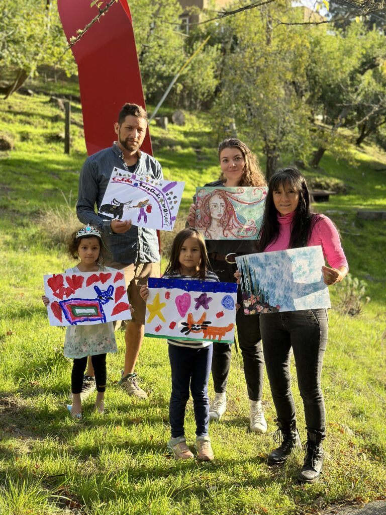 Photo of family members with their artwork on the hillside at O'Hanlon